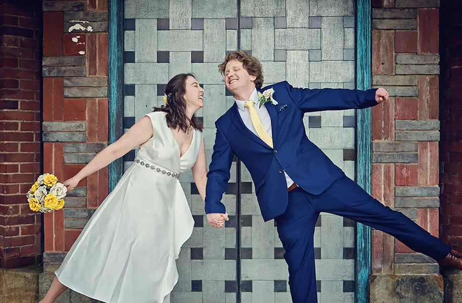 Newly married couple holding hands outside The Hive in Worcester