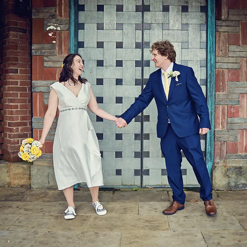 Newyweds holding hands outside registry office