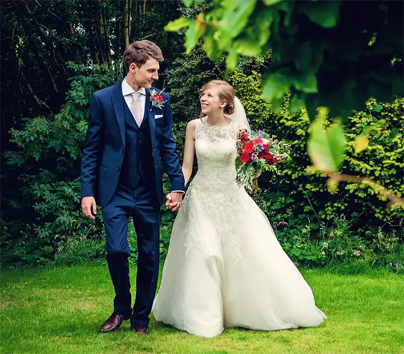 Bride and groom walking through summer gardens